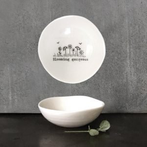 a small white porcelain dish with. an irregular shape. Printed on the inside with a line of illustrated flowers and the words blooming gorgeous. a lovely gift for a special friend