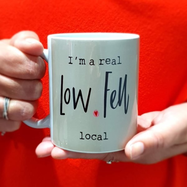 A ceramic mug with I'm a real Low Fell local printed on it. A stone grey background and a little heart finish this stylish and amusing mug