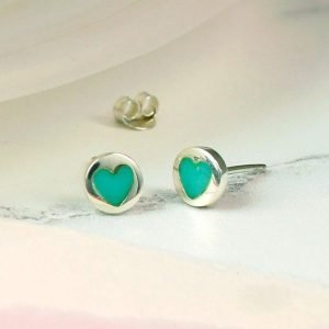 A pair of small sterling silver turquoise heart earrings.