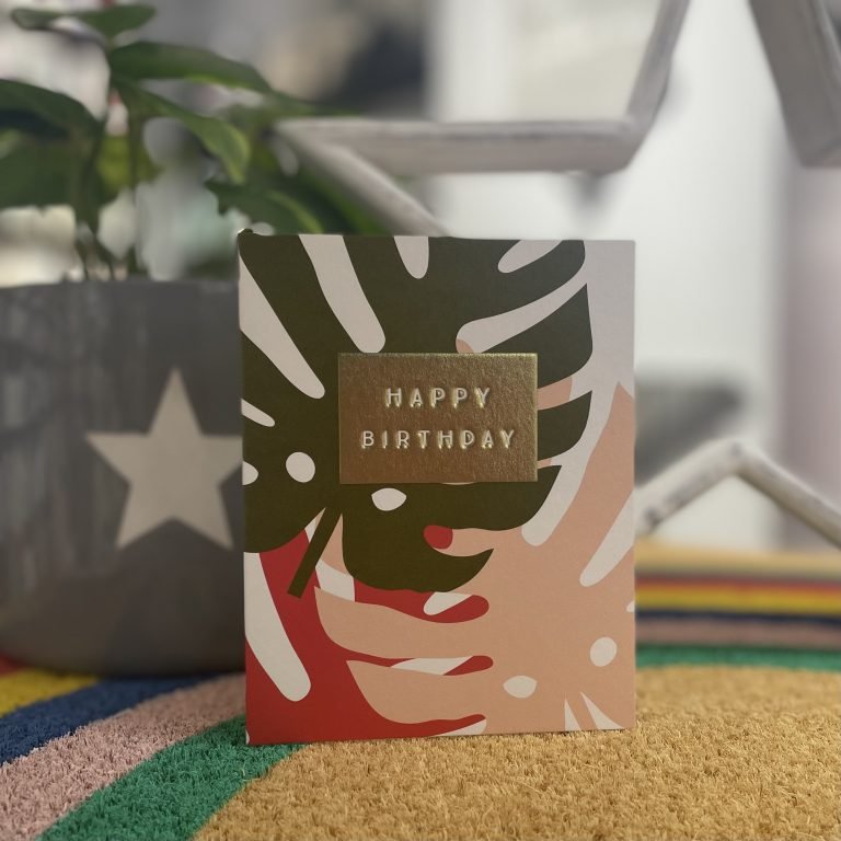 A sweet card from Think of Me's Jot range. With an image of Monstera leaves and the words Happy Birthday embossed and printed on a gold oblong in the centre of the card.