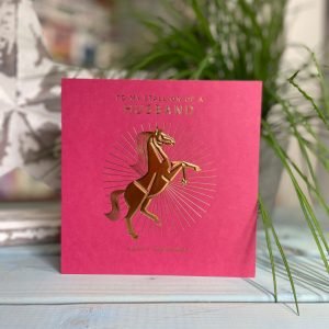 A red square card with a goild foil image of a horse on it and the words To My stallion of a husband printed on it.