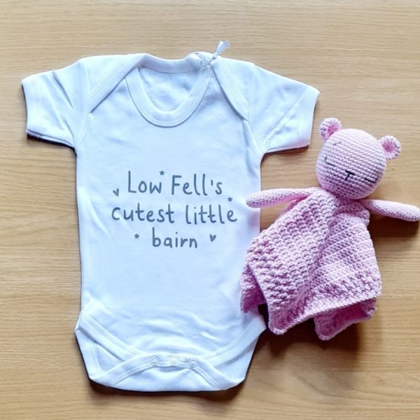 A white baby vest printed in grey with Low Fell's cutest little bairn.