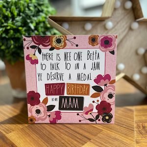 A Mam birthday card with a pink flowery background and a poem prnted Ther is nee one betta to talk to in a jam Ye deserve a medal Happy Birthday to me Mam