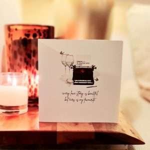 Our Love Story Valentine's Day Card by Five Dollar Shake.. A luxury white shimmering board printed with a typewriter and two glasses of wine and butterflies. The page in the typewriter has 