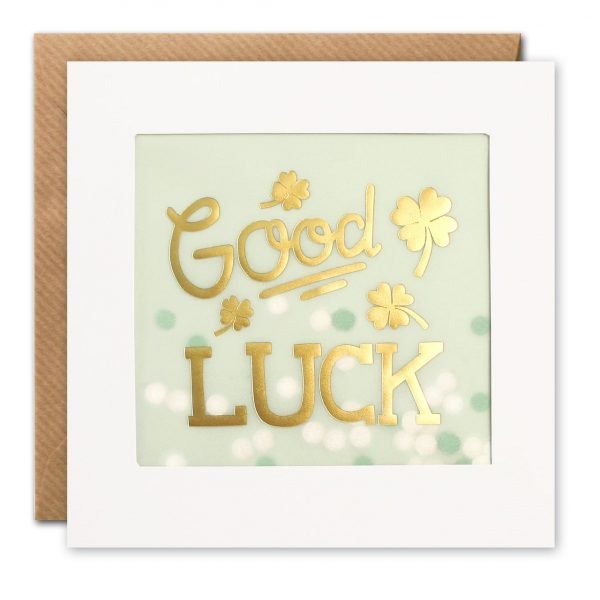 A good luck card. The image on the front is foiled in gold and shows the words 'Good Luck' surrounded by gold four leaf clovers, on a pale green background. The image is printed on translucent paper, showing cream and green paper confetti dots behind. The confetti moves around when you shake the card.