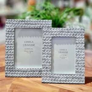 A pair of picture frames in resin with a grey wash finish and an engraved thatch pattern