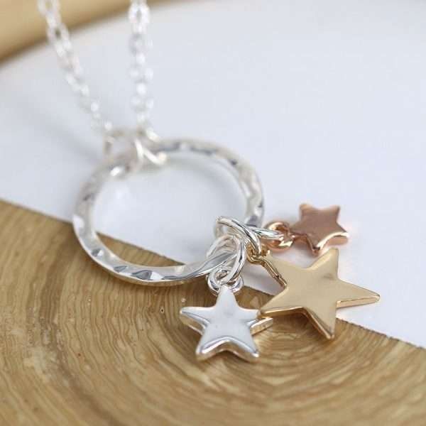 Triple Star Necklace. Silver plated split chain necklace with a hammered silver plated hoop pendant and three star charms of different sizes in contrasting silver, gold and rose gold style finishes. This necklace is fastened with a lobster clasp and has an extension chain to adjust the length.