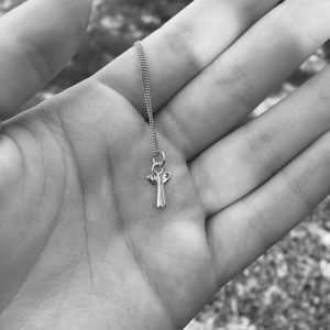 A sterling silver necklace with a silver angel pendant