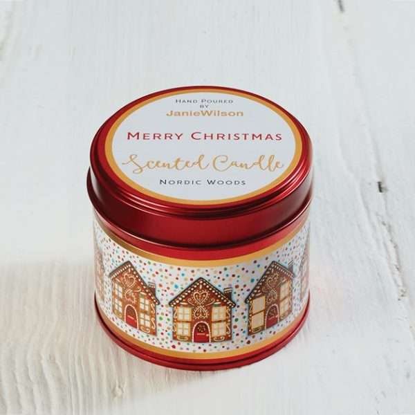 A 250mlnordic woods scented Christmas candle in a red tin decorated with cute gingerbread houses and Merry Christmas on the lid