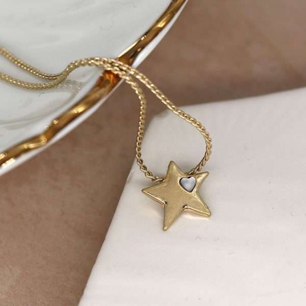 Fine chain necklace with a single star shaped pendant, plated in a faux gold finish and inset with a tiny heart shaped white quartz. This necklace is fastened with a lobster clasp.