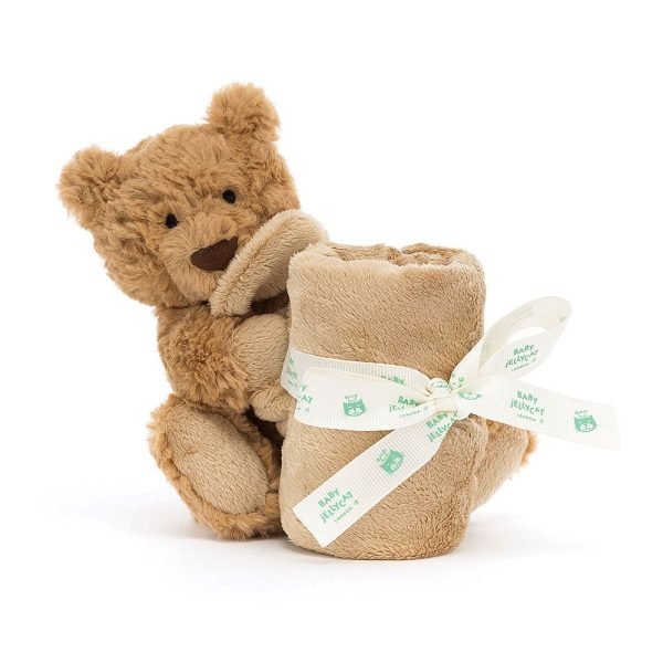 A brown softly textured toy bear is hugging an un-stuffed square shaped soother blanket