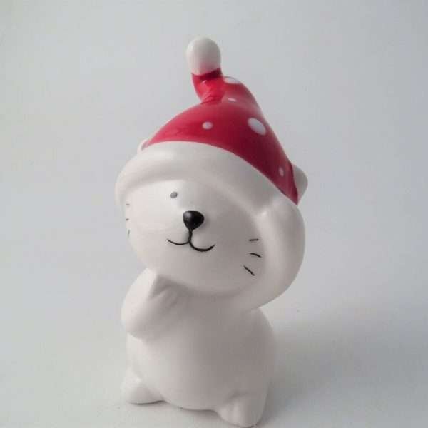 A little white ceramic cat in a red Christmas hat
