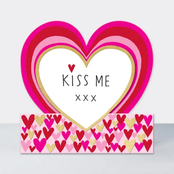 Die cut heart shaped card printed iwht lots of pink hearts and the words Kiss Me xxx in the heart