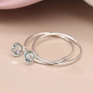 Sterling silver fine sleeper hoop earrings with faceted round blue topaz drops