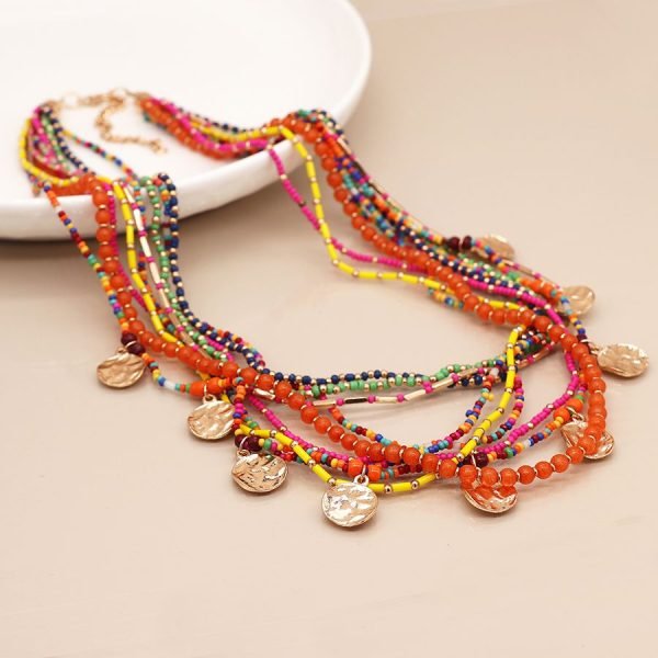 Multi strand necklace with a mix of orange, yellow, pink and green beads and hammered metallic discs.